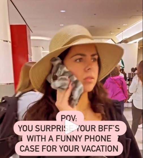 A traveler speaking on her cell phone, wearing a hat. Text says: POV: Your surprise your BFF's with a funny phone case for your vacation. 