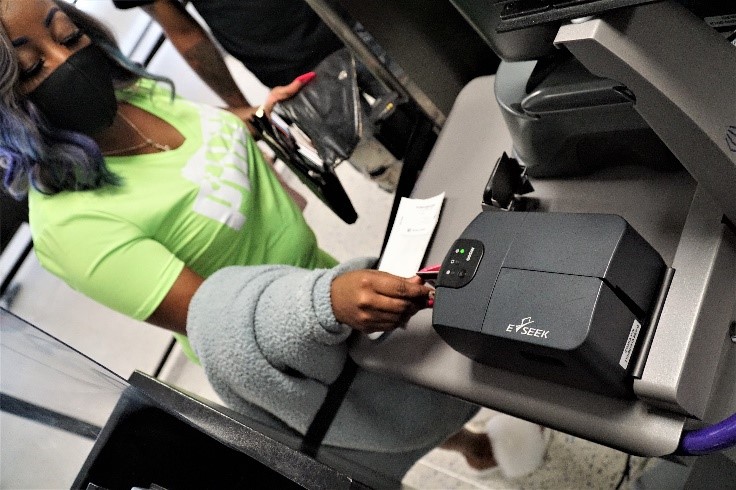 A traveler inserts her ID into the new credential authentication technology unit. (TSA photo)