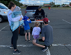 A mom and her two children get an up close look at a drone and engage with (from left) FAA Inspector Mike Edreich, TSA Officer Greg Deschenes, and Senior Federal Air Marshals Clough and Cain. (Photo by Steve Blindbury)