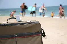 Luggage and people on a beach. 