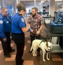 TSA officers explain screening procedures to veteran with his dog