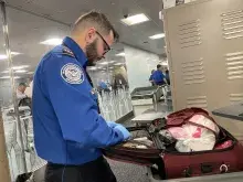 Phoenix Sky Harbor International Airport TSA Officer Shemsi Papraniku conducts a bag search. (Photo by Patricia Mancha)