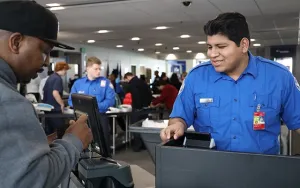 Detroit Metropolitan Wayne County Airport TSA Officer Dominic Cherenzia welcomes a passenger to the TSA checkpoint. (Photo by Robert Gilmore)