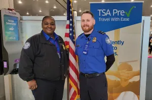 Miami International Airport (MIA) Lead TSA Officers Shanquita Auguste (left) and Zachary Leighton teamed together to save a passenger’s life at MIA Checkpoint 2. (Photo courtesy of TSA MIA)