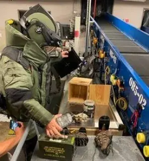 In the checked bag scenario, an integrated EOD team member in a bomb suit used a portable X-ray machine to identify and dismantle the obvious threat