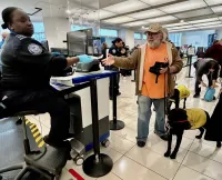 Lead TSA Officer Maria Onadelco greets guide dog and trainer. (Lisa Farbstein photo) 