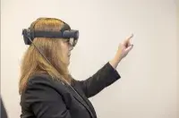 TSA Deputy AdministratorHolly Canevari tests the Microsoft HoloLens mixed reality headset. (Photo by Bruce Milton)