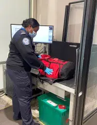George Bush Intercontinental Airport Supervisory TSA Officer Alina Jones conducts a bag search. (Photo by Daphanie Larkin)