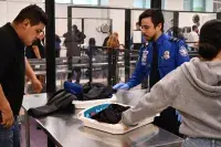 With the assistance of TSA Officer Armand Perez, a young man goes through a TSA checkpoint during his school group’s airport experience at LAX. (Photo courtesy of the Downey Unified School District)