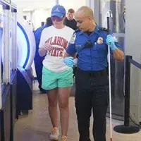 Lubbock Preston Smith International Airport Lead TSA Officer David Reyes-Velez assists a Texas Tech University student through the walk through metal detector. (Photo by Tom Harper)