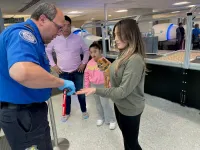 After walking through the metal detector, a TSA officer swabs the hands of a passenger who carried her pet dog through the security checkpoint. (TSA photo)