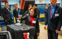 Josephine de Ocampo of the Philippines’ Office for Transportation Security tries out the tool to move heavy checked bags. (Photo by Amanda Adams)