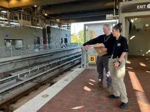 TSIs Riley Flynn (right) and Thomas Pitts discuss security on the track bed along the platform at the Potomac Yard-Virginia Tech Metrorail station in Alexandria, Virginia. (TSA photo)