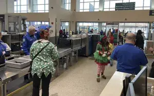 TSA officers screen passengers, including some of Santa’s elves, who joined dozens of underserved children for a special flight from Spokane International Airport to the North Pole. (Photo courtesy of TSA GEG)