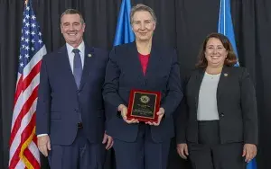 Administrator Pekoske and Senior Official Performing the Duties of the Deputy Administrator Stacey Fitzmaurice recognize TSA Alaska/Ted Stevens Anchorage International Airport as the 2022 CAT X-I Airport of the Year. Administrative Officer Ginger Bateman (center) accepts the award at the annual TSA Honorary Awards Ceremony. (Photo by Bruce Milton