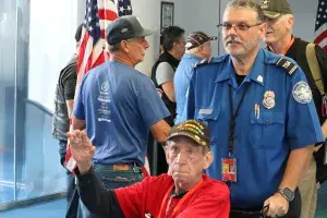 Lead TSA Officer William Gibson pushes a Vietnam War veteran’s wheelchair. (TSA Michigan Media photo) 