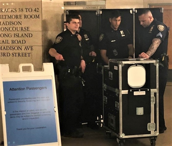 Police officers use the Thruvision TAC passive screening device to screen passengers who pass in front of the unit during a field assessment inside Grand Central Terminal in New York City. (TSA photo)